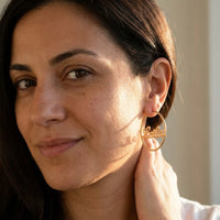 Thumbnail for Custom Name Hoop Earrings in Gold worn on the ear, close-up on a model | SKU: name-hoop-gold-30-mm