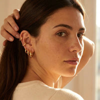 Thumbnail for Huggie Hoop Earrings Set of 4 Pairs in Gold worn on the ear, close-up on a model | SKU: huggie-set-gold