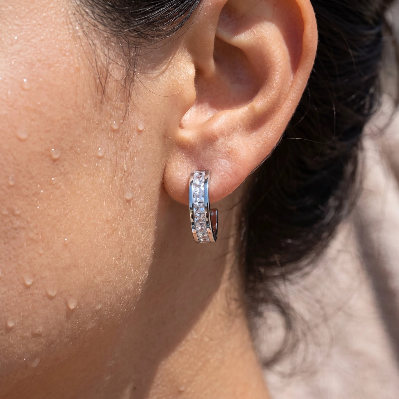 Huggie hoop earrings — close-up of the details, silver | SKU: 22023999-rhodium
