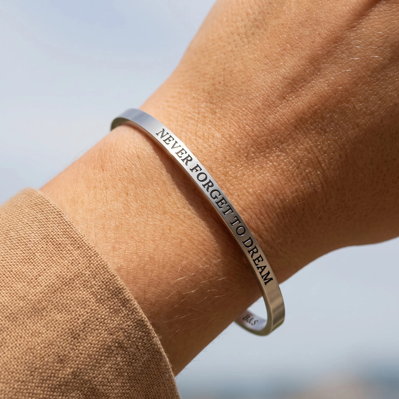 Close-up of the Never Forget To Dream bracelet in silver worn | SKU: nftd-wg