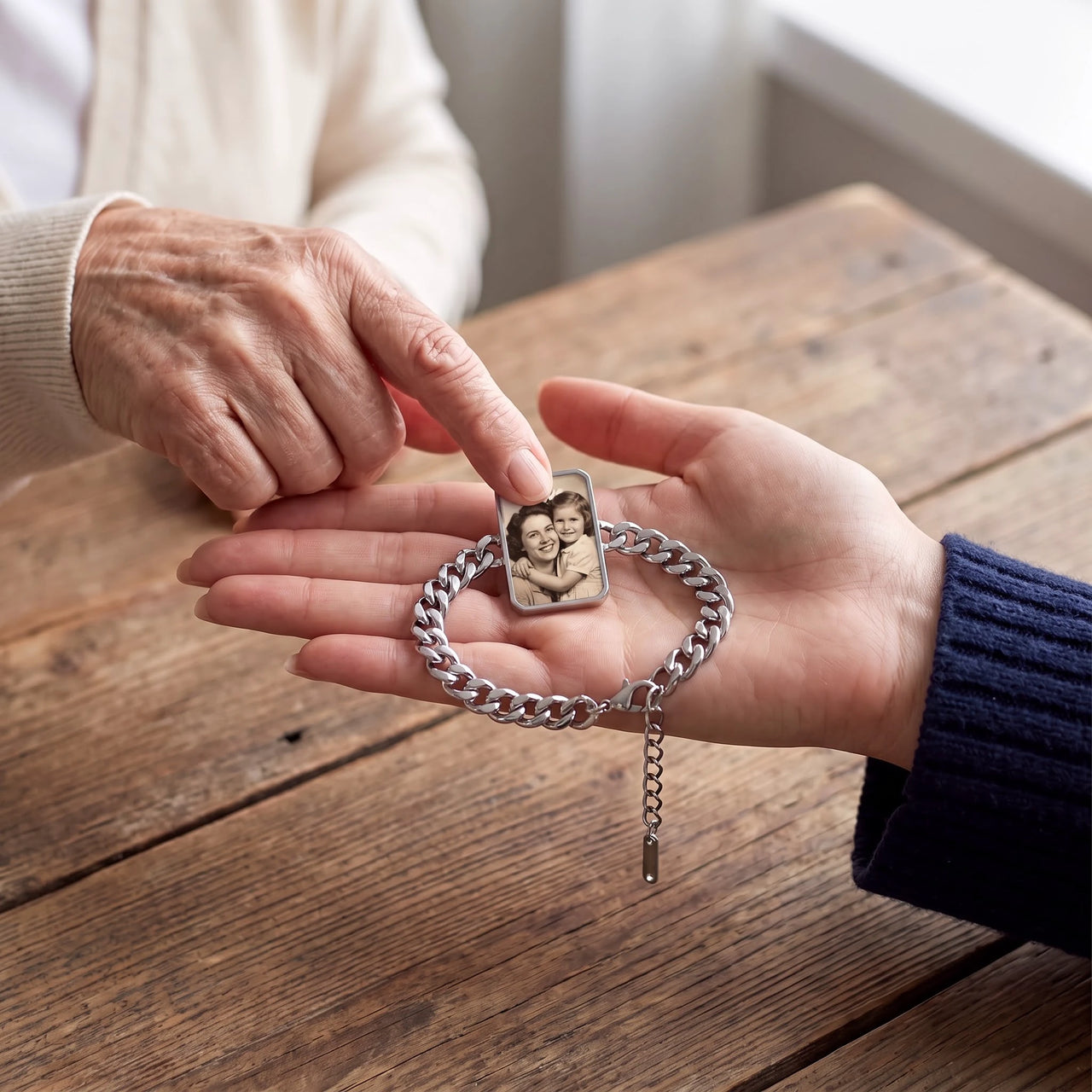 An elderly mother's fingertip on the silver cushion-cut photo bracelet in her daughter's palm, showing their mother-and-daughter photo | SKU: TPH-CUSB-SILVER